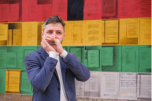 Man plays harmonica outdoors in city
