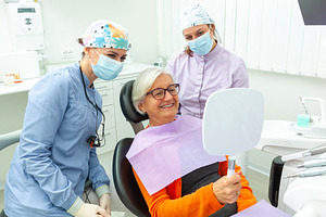 Senior woman admiring her smile after dental treatment, a Health & Medical Photo by Antonio Gravante Market