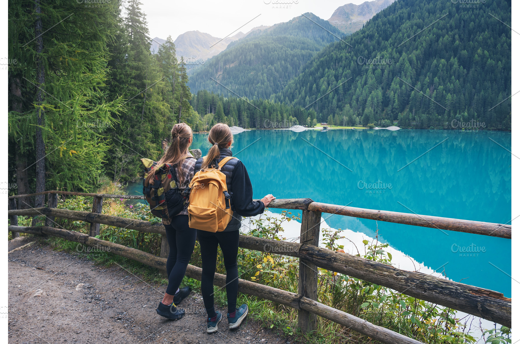 Two women with backpacks standing, a Person Photo by den-belitsky