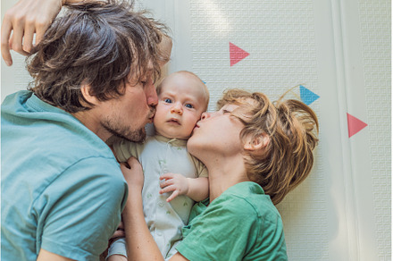 Father, son, and newborn baby lying