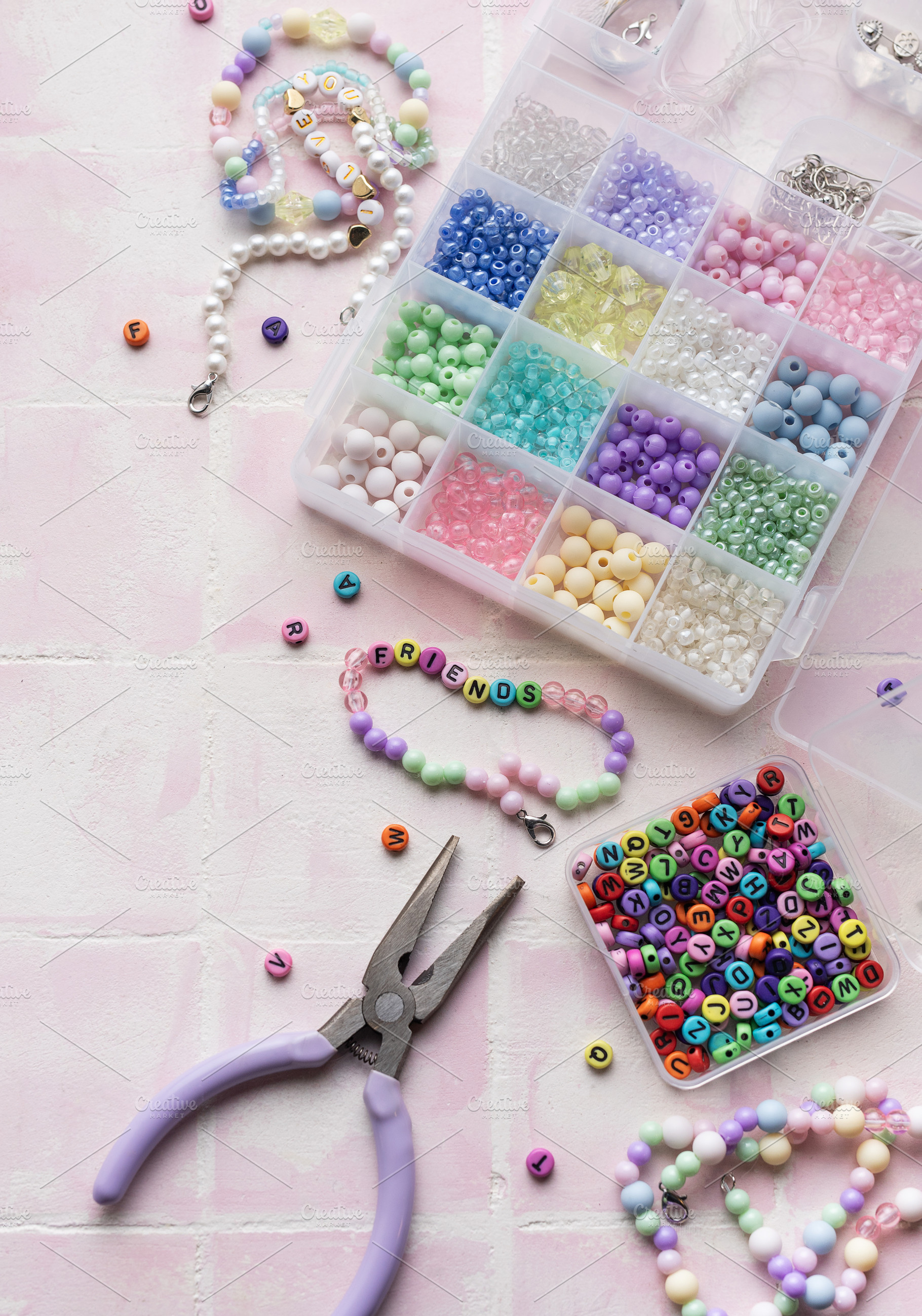 Colorful beads and pliers arranged on pink tile for jewelry maki, an Arts & Entertainment Photo by Olena Rudo