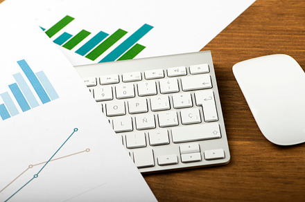 Business graphs next to computer keyboard financial data stock photo, a Business Photo by José Luis Agudo