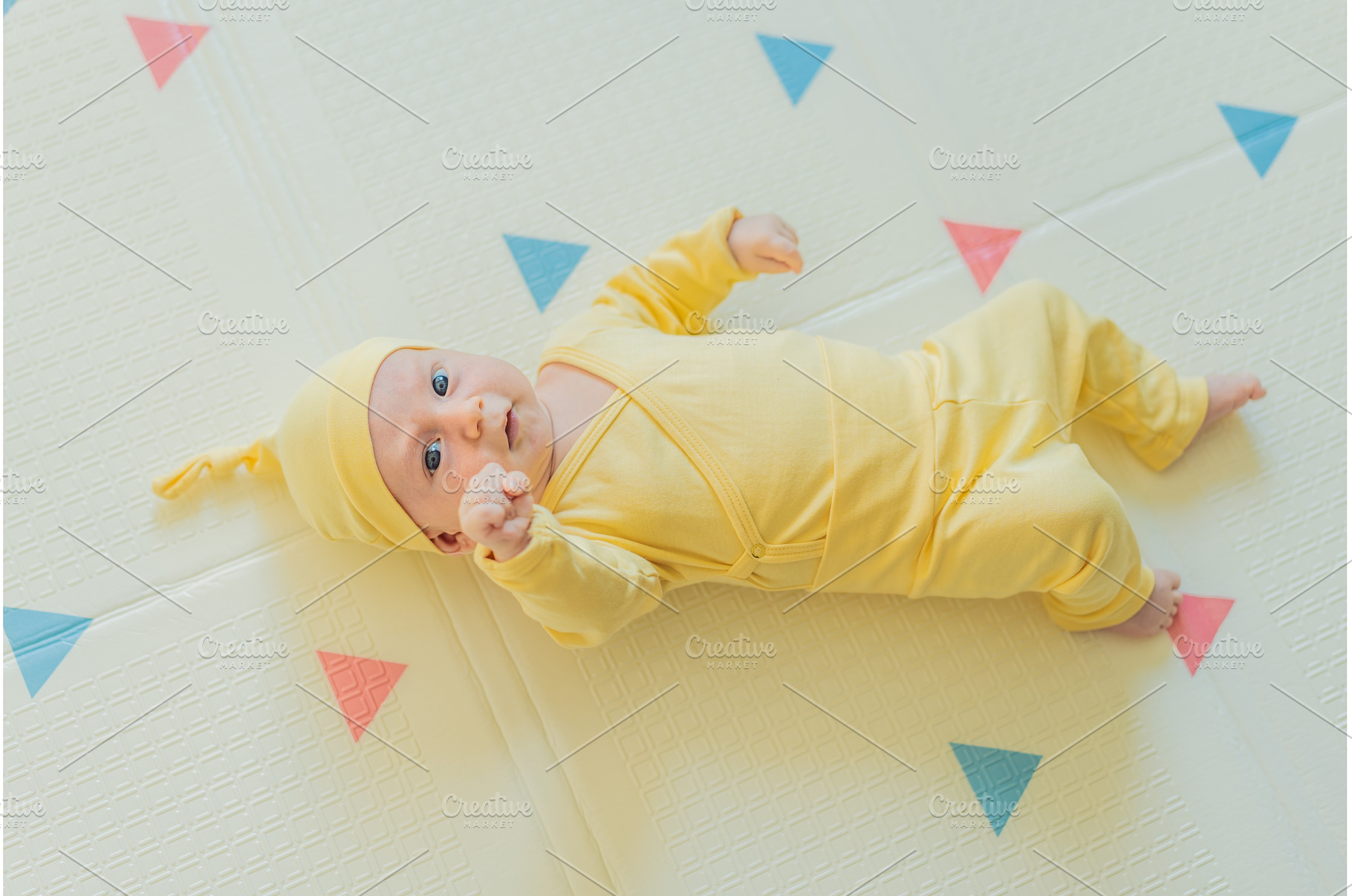 Adorable baby in a yellow hat lying, a Person Photo by Elizaveta Galitskaya