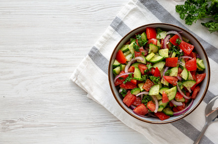 Homemade Mediterranean Cucumber Tomato Salad in a Bowl, top view, a Food & Drink Photo by LiudmylaChuhunova