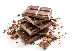 Milk chocolate pieces on white background, a Food & Drink Photo by AlyaAnd