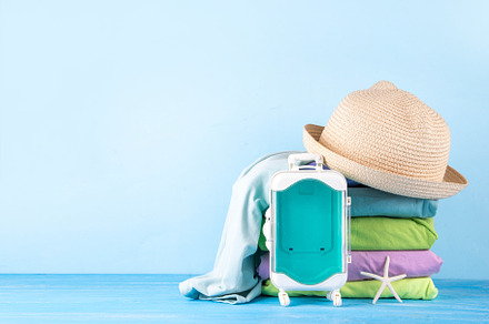 Summer bright clothes pile stack on wooden light blue table, a Holiday Photo by Rimma