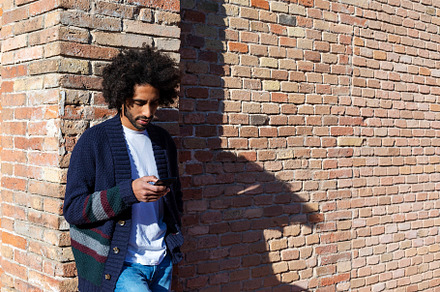 Young afro man using cellphone outdoor, a Person Photo by 2Design