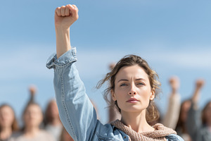 Determined woman raises her fist in, a Photo by MistyDay