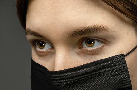 Brunette woman in a medical mask.