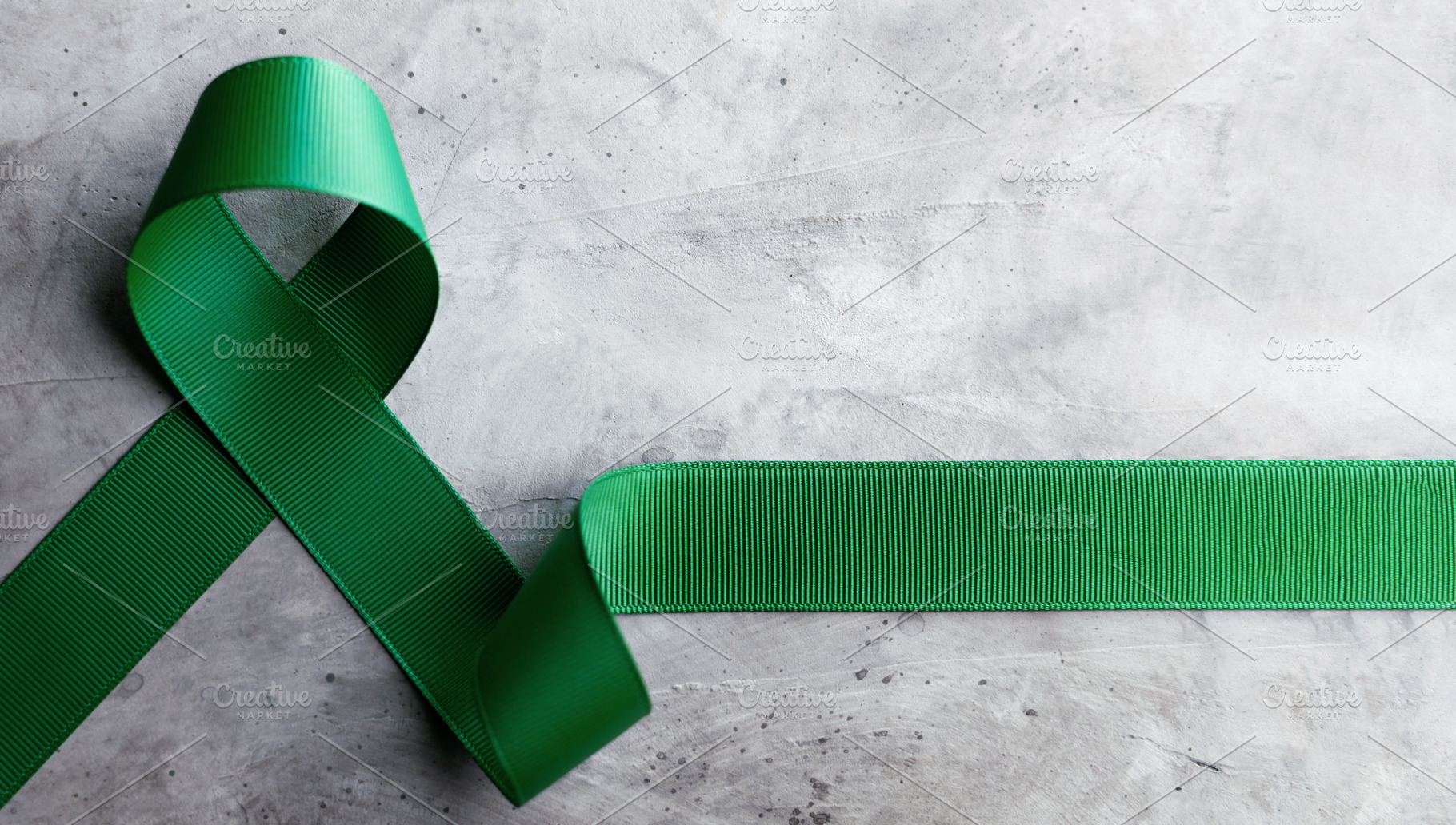 Mental Health Awareness Concept. Green Ribbon lay on Grey backgr, a Photo by salmon.black