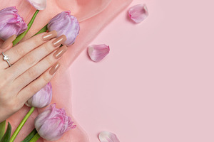 Woman showing stylish nude manicure with tulips on pink backgrou, a Beauty & Fashion Photo by Olena Rudo