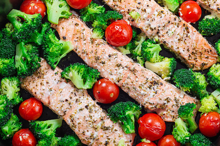 One pan dish baked salmon fillet with broccoli and tomato, horizontal, top view, a Food & Drink Photo by iuliia_n