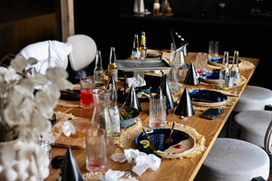 Casual party table with drinks and decorations after a lively gathering, a Photo by AS photostudio