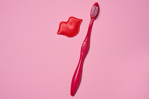 Red toothbrush and red decorative lips placed on a pink backgrou, a Health & Medical Photo by ndanko
