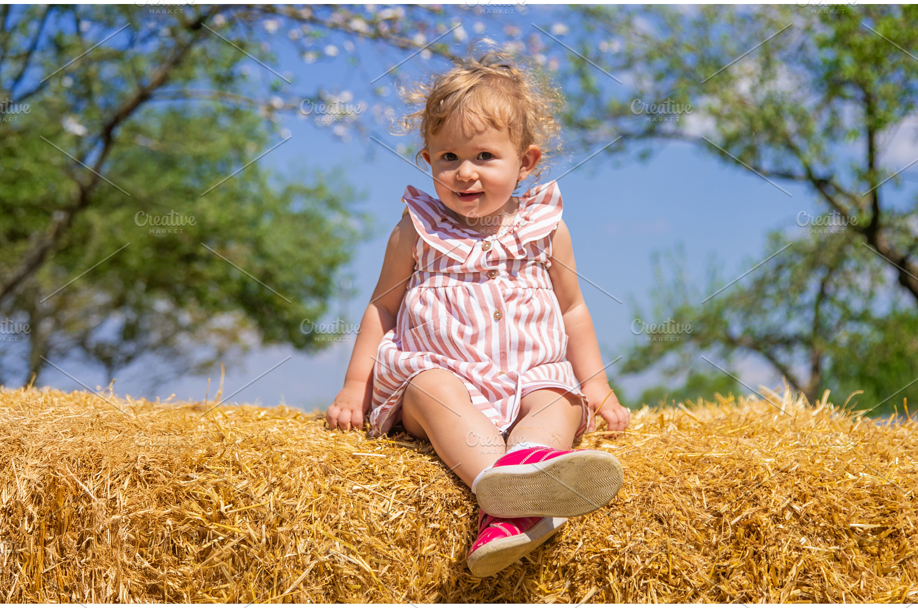 The child is sitting on a pile of, a Nature Photo by yanadjana