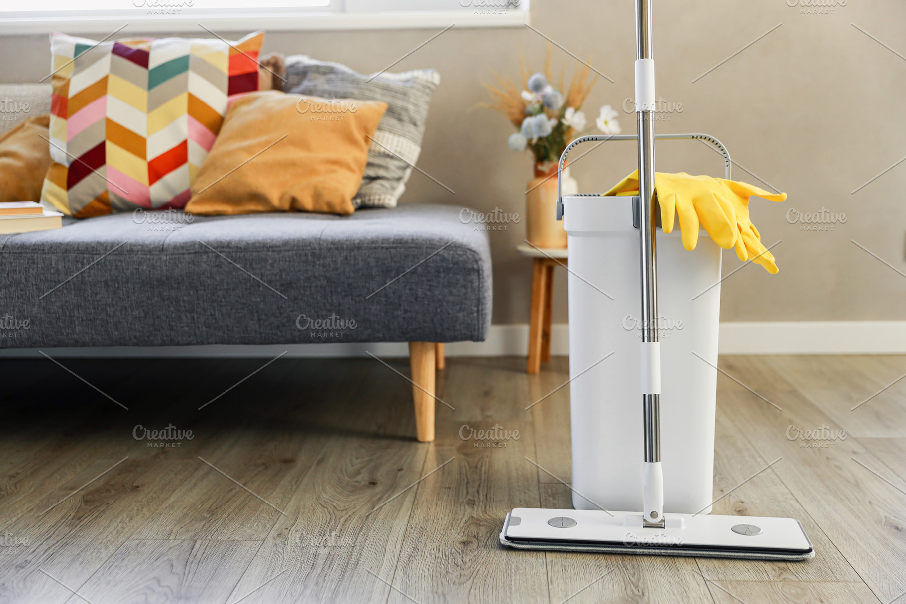 Cleaning supplies: mop, gloves, bucket with wringer on wooden laminate floor, a Business Photo by Lenor4ik