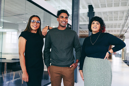 Happy team of businesspeople smiling while standing together, a Person Photo by Jacob Lund