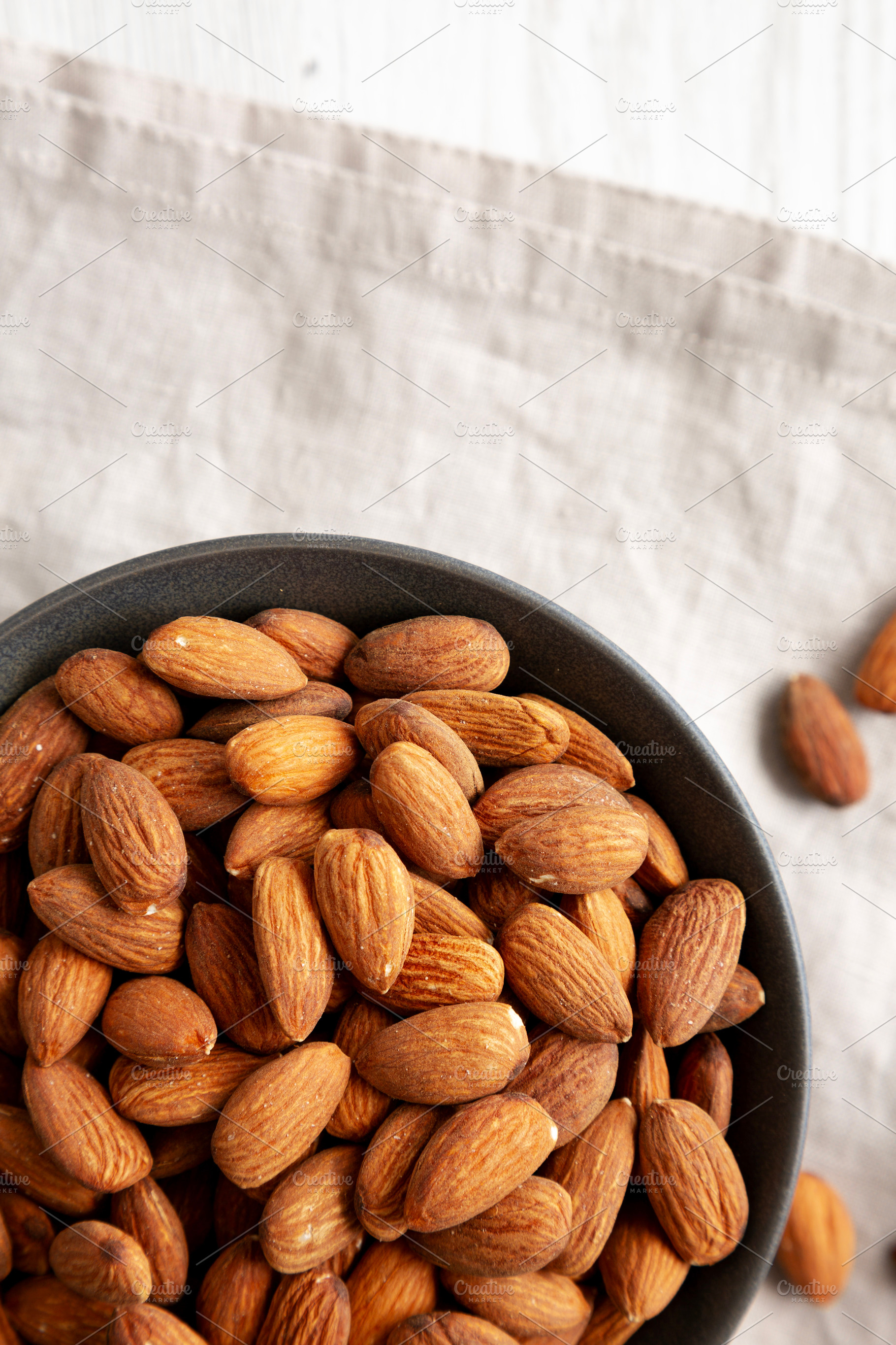 Roasted Almonds in a Bowl, top view. Flat lay, overhead, from ab, a Food & Drink Photo by LiudmylaChuhunova