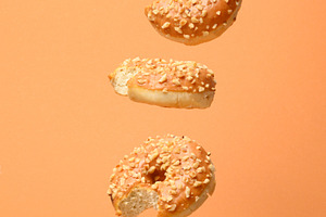 Vertical composition of levitating bitten caramel donuts with nu, a Food & Drink Photo by ndanko