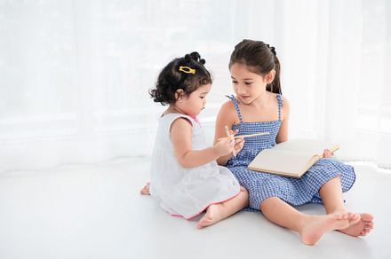 Happy two sister drawing in sketch book together at home. People, a Person Photo by Ministocker