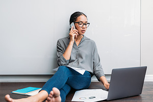 Young female using a laptop and talk, a Business Photo by Artem Varnitsin