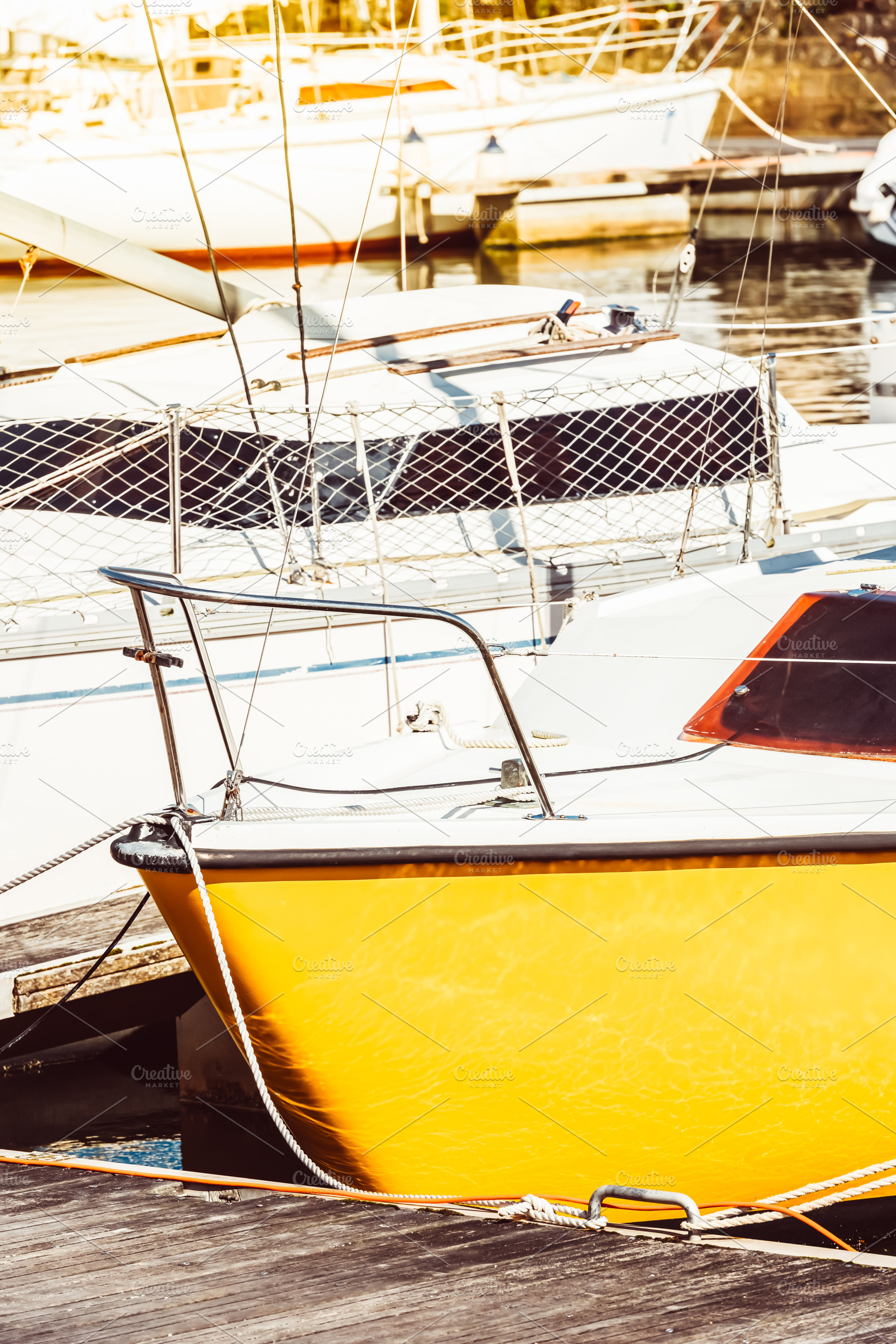 Yellow sailboat in sunny marina, a Photo by Dvoevnore photos