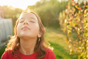 Girl enjoys the warmth of sunlight