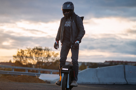 A man rides on an electric unicycle. Mono Wheel riding (EUC) , protective gear