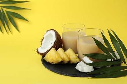Pina colada cocktails and ingredients on yellow background, a Food & Drink Photo by AtlasStudio PRO