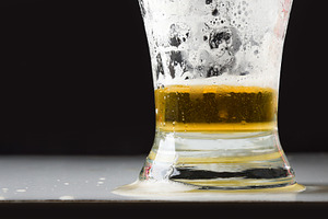 Detail of empty beer glass with foam isolated on black, a Food & Drink Photo by Davizro's Market