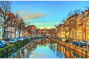 Traditional houses beside a canal in containing leiden, netherlands, and canal, an Architecture Photo by Leonid Andronov