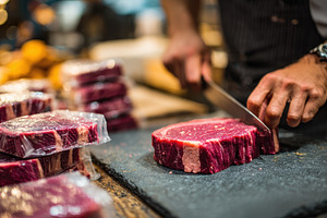 Butcher cutting premium steak meat m, a Photo by Pixeness Studio