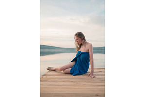 Woman in Blue Towel Sitting on Dock, a Person Photo by Jan Jack Russo Media