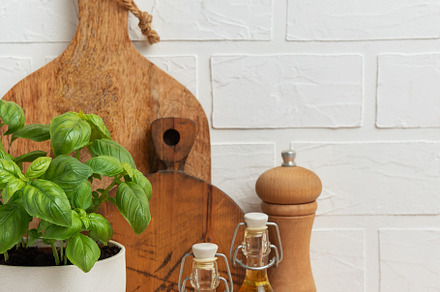 Fresh basil, olive oil, pepper mill and cutting boards resting o, a Food & Drink Photo by Olena Rudo
