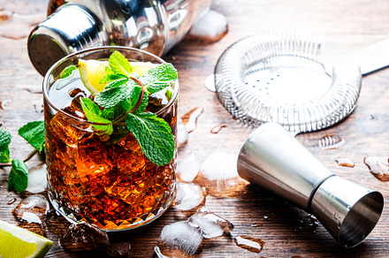 Rum cola cocktail drink with strong alcohol, mint, ice and lime
