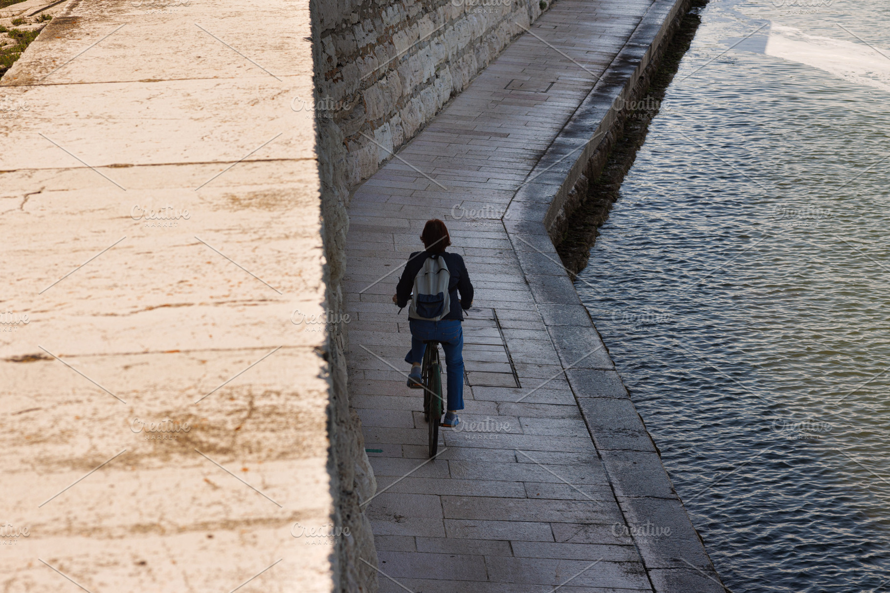 Woman riding bike in Pellestrina Island, a Transportation Photo by Bepslabor