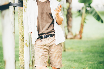 Smiling man with smartphone in park, a Person Photo by SkyNext