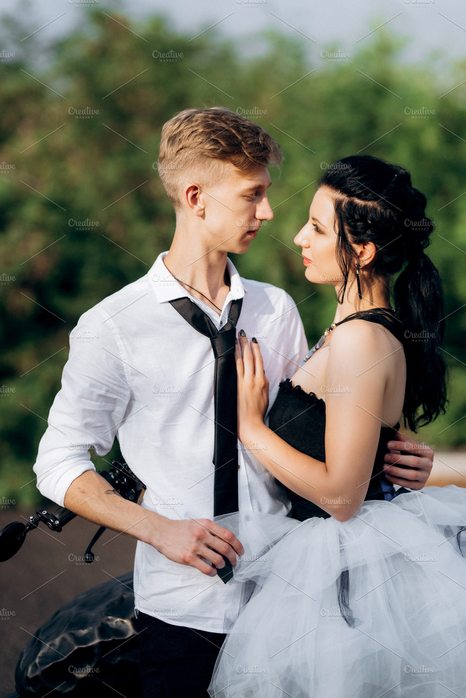 A couple of newlywed freaks on a black custom bike, a Person Photo by Weddings, People, Travel