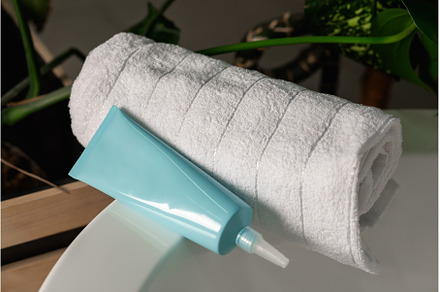 Tube of scalp scaler and towel in