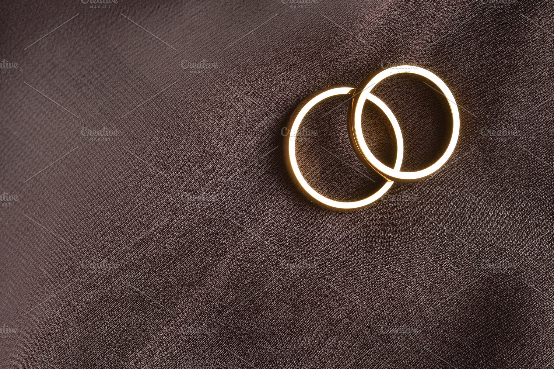 Overlapping Gold Rings on Dark Brown Fabric, an Abstract Photo by Davizro's Market