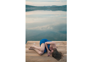 Woman in Blue Towel Sitting on Dock, a Person Photo by Jan Jack Russo Media