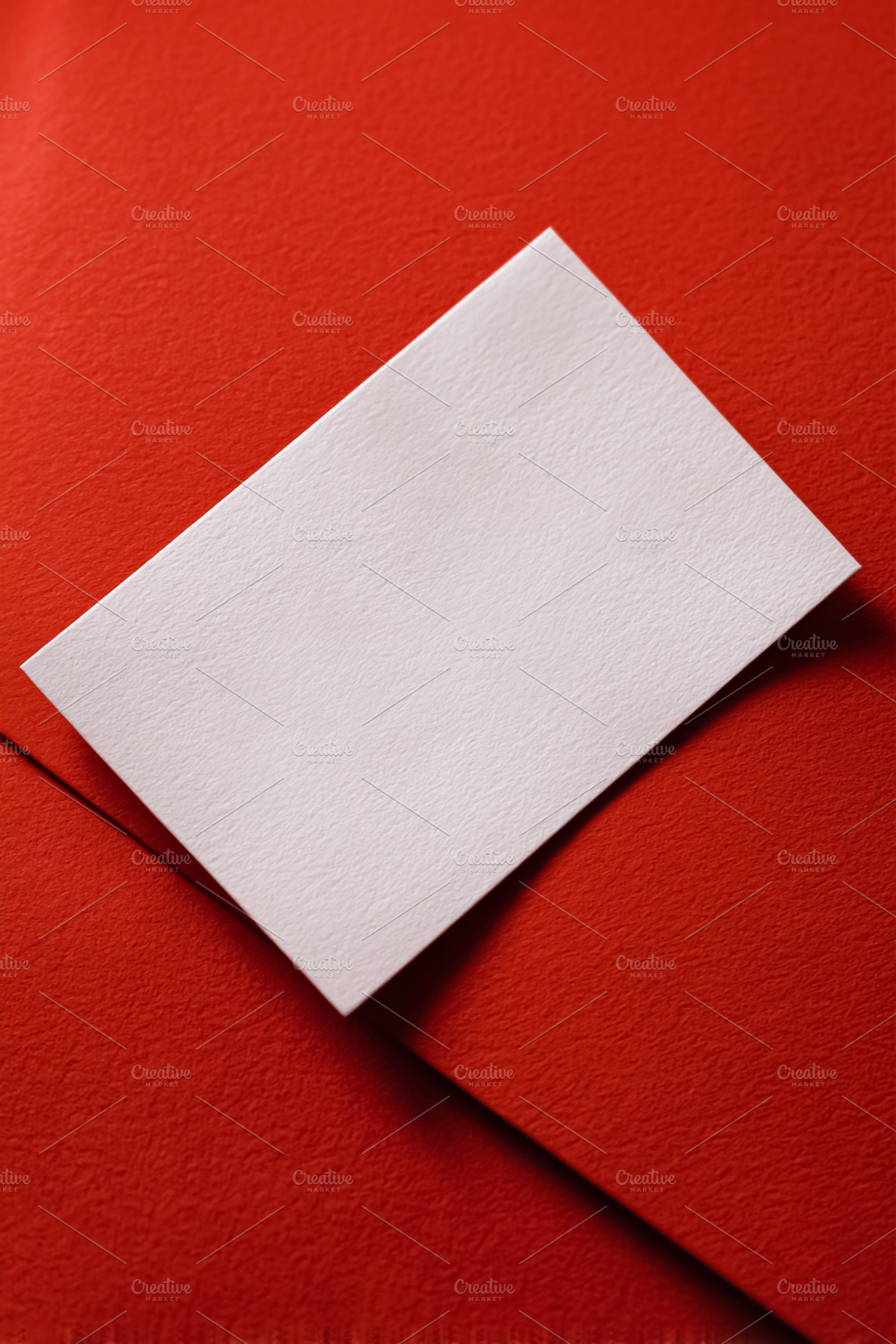 Blank white textured card mockup on a vibrant red background, pe, a Photo by Studio ANNA