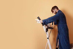 Young man using stationary bike in blue bathrobe against pastel, a Person Photo by Ales Munt