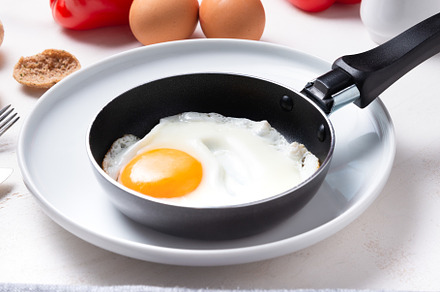 Scrambled, frying  eggs from one egg in a small pan on porcelain, a Food & Drink Photo by MDBildes