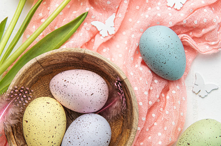 Easter background with colorful eggs in bowl and pink tulips, a Holiday Photo by Olena Rudo