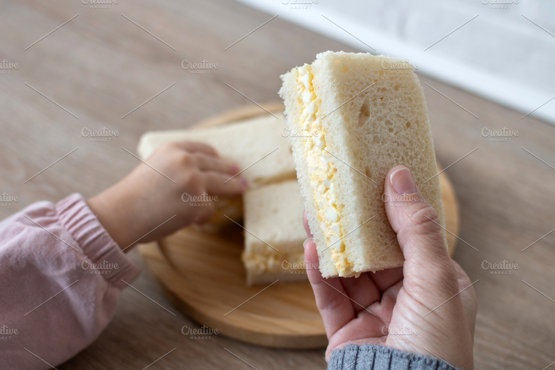 Woman taking a tamago Sando sandwich wth her daughter, a Photo by etorres69