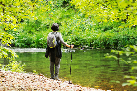 Woman hiking in the river containing hill, sunlight, and backpack, a Sports & Recreation Photo by Genaro Diaz photographs