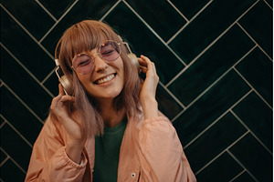 Young woman wearing headphones and, a Person Photo by HalfPoint