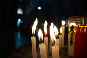 Candles lit in a church, creating a serene atmosphere, a Background Photo by GoodGoods