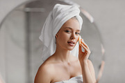 Moisturizing skin after shower. Pretty millennial woman in towel covering her e, a Photo by Prostock-Studio (Thumbnail 3 of 3)